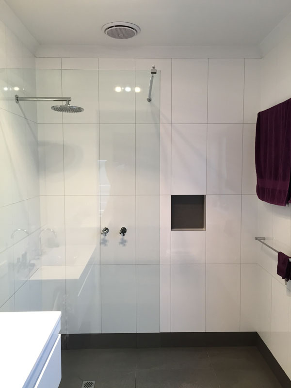 Minimalist bathroom with clean white shower tiling in Penrith, showcasing modern aesthetics